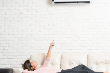 Woman Turning On Mini Split At Home