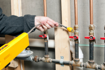 Worker Using a Leak Detector near House Gas Lines
