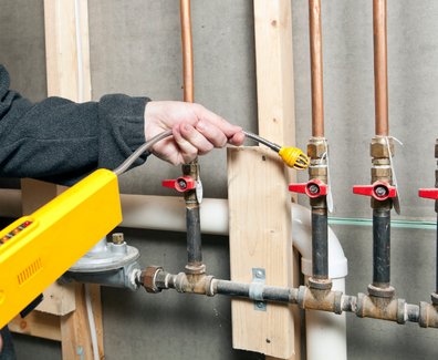Worker Using a Leak Detector near House Gas Lines