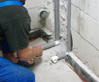 Plumber installing pipes
