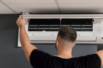 Male Technician Repairing Air Conditioner Indoors