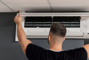 Male Technician Repairing Air Conditioner Indoors