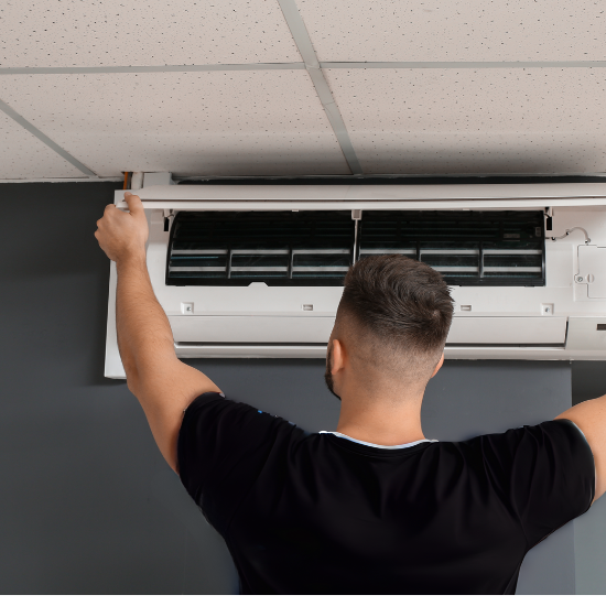 Male Technician Repairing Air Conditioner Indoors