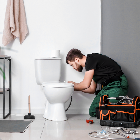 Plumber Installing Toilet Bowl in Bathroom