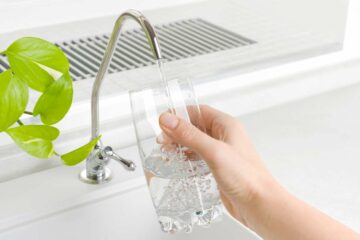 Clean filtered water coming from a tap into a glass.