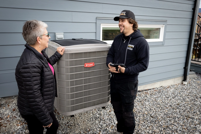 Vision HVAC tech performing a heat pump inspection with a client in Kelowna BC