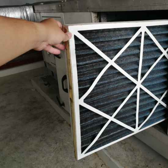 HVAC technician replacing a furnace filter